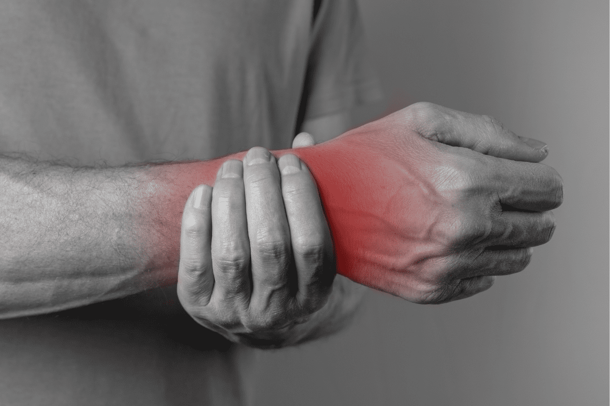 man holding red and swollen wrist to indicate CRPS